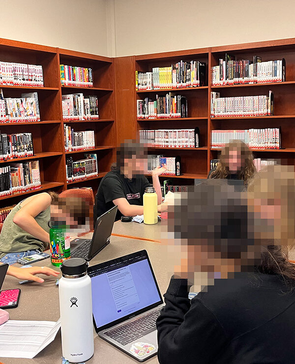 A group of students reading around a desk.